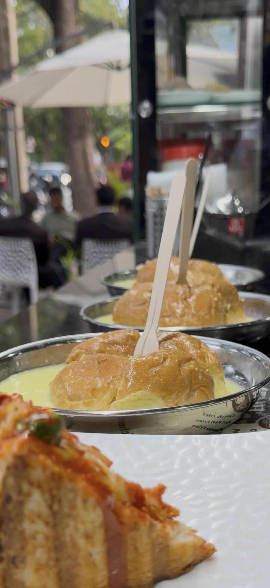 Bun served with hot milk on the outdoor tables